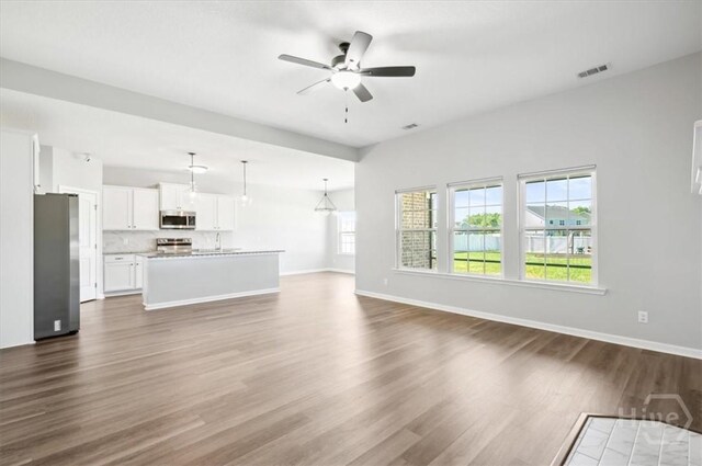 301 Akins Ranch Rd NE, Ludowici, GA 31316 - unfurnished living room with dark wood-type flooring, a ceiling fan, and baseboards
