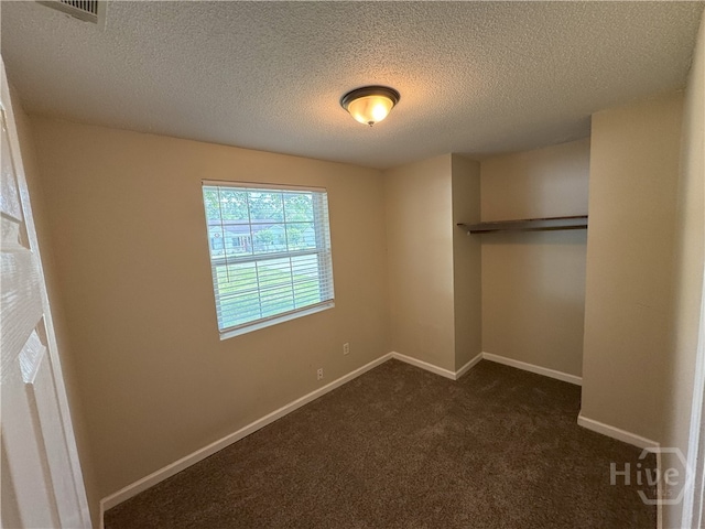115 New Stillwell Rd, Springfield, GA 31329 - unfurnished bedroom with a textured ceiling, dark colored carpet, baseboards, and a closet
