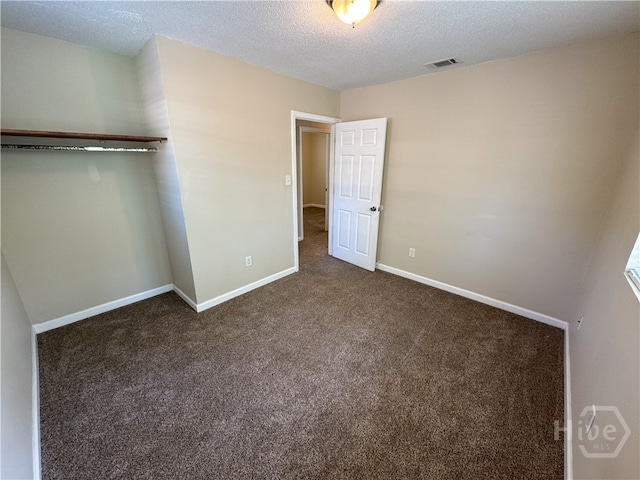 115 New Stillwell Rd, Springfield, GA 31329 - unfurnished bedroom featuring a textured ceiling, dark colored carpet, and baseboards