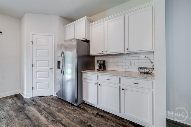 202 Thatcher St, Guyton, GA 31312 - kitchen with stainless steel refrigerator with ice dispenser, white cabinetry, dark wood-style flooring, tasteful backsplash, and light stone countertops