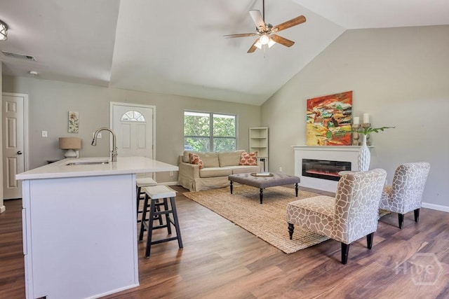 1522 Marcy Cir, Savannah, GA 31406 - living room featuring a ceiling fan, dark wood-style flooring, a glass covered fireplace, high vaulted ceiling, and baseboards