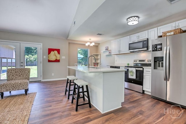 1522 Marcy Cir, Savannah, GA 31406 - kitchen featuring appliances with stainless steel finishes, a sink, white cabinets, a chandelier, and vaulted ceiling