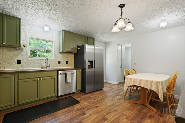 132 Waymaker Dr, Midway, GA 31320 - kitchen with green cabinetry, stainless steel appliances, dark wood-type flooring, a chandelier, and a textured ceiling