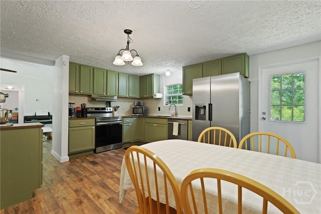 132 Waymaker Dr, Midway, GA 31320 - kitchen with green cabinets, appliances with stainless steel finishes, under cabinet range hood, dark wood-type flooring, and a textured ceiling