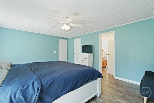 132 Waymaker Dr, Midway, GA 31320 - bedroom featuring wood finished floors, a textured ceiling, baseboards, a ceiling fan, and connected bathroom