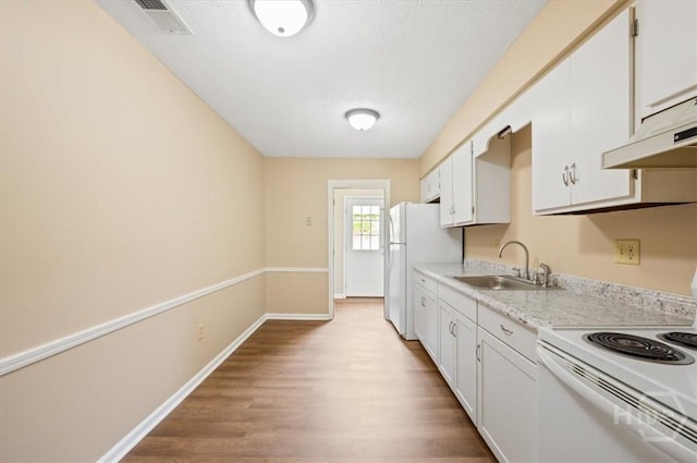 310 Ashmore St Unit A, B, Hinesville, GA 31313 - kitchen featuring white appliances, a sink, light wood-type flooring, light countertops, and white cabinetry