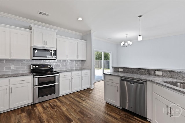 194 Shortleaf Trl, Richmond Hill, GA 31324 - kitchen with appliances with stainless steel finishes, a chandelier, dark wood finished floors, white cabinetry, and backsplash