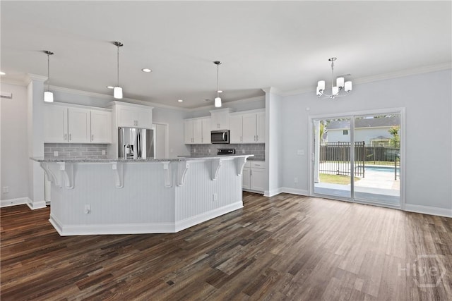 194 Shortleaf Trl, Richmond Hill, GA 31324 - kitchen with appliances with stainless steel finishes, backsplash, dark wood-type flooring, white cabinets, and a chandelier
