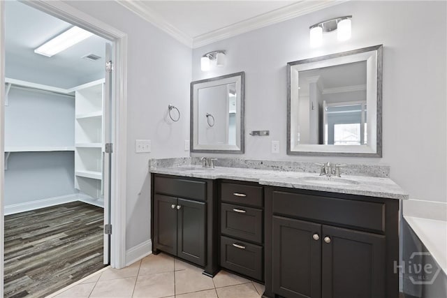 194 Shortleaf Trl, Richmond Hill, GA 31324 - bathroom featuring double vanity, ornamental molding, tile patterned flooring, baseboards, and a walk in closet