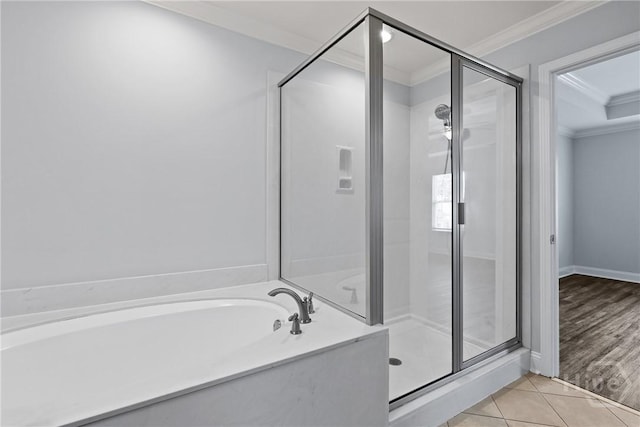 194 Shortleaf Trl, Richmond Hill, GA 31324 - bathroom featuring ornamental molding, a shower stall, a garden tub, tile patterned floors, and baseboards
