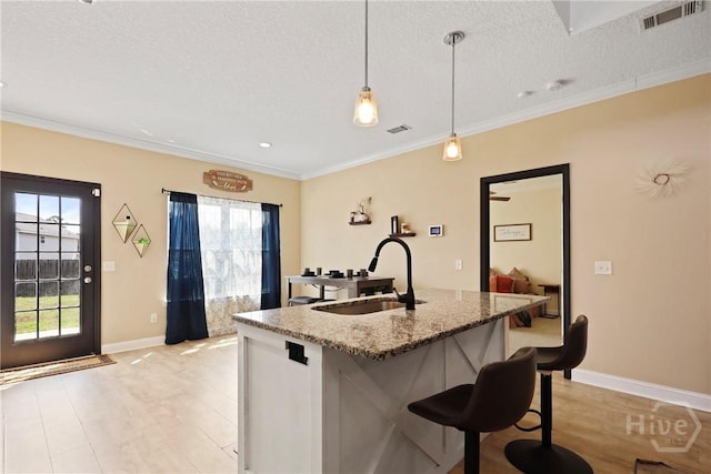 806 Fairview Cir, Hinesville, GA 31313 - kitchen featuring a sink, healthy amount of natural light, a textured ceiling, a center island with sink, and baseboards