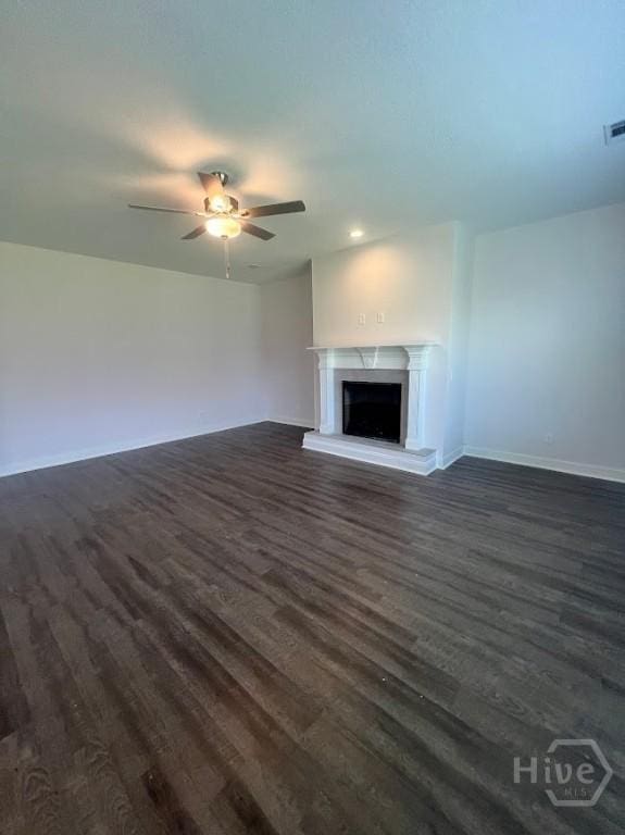 139 Sams Dr, Guyton, GA 31312 - unfurnished living room featuring dark wood finished floors, a ceiling fan, baseboards, a premium fireplace, and recessed lighting
