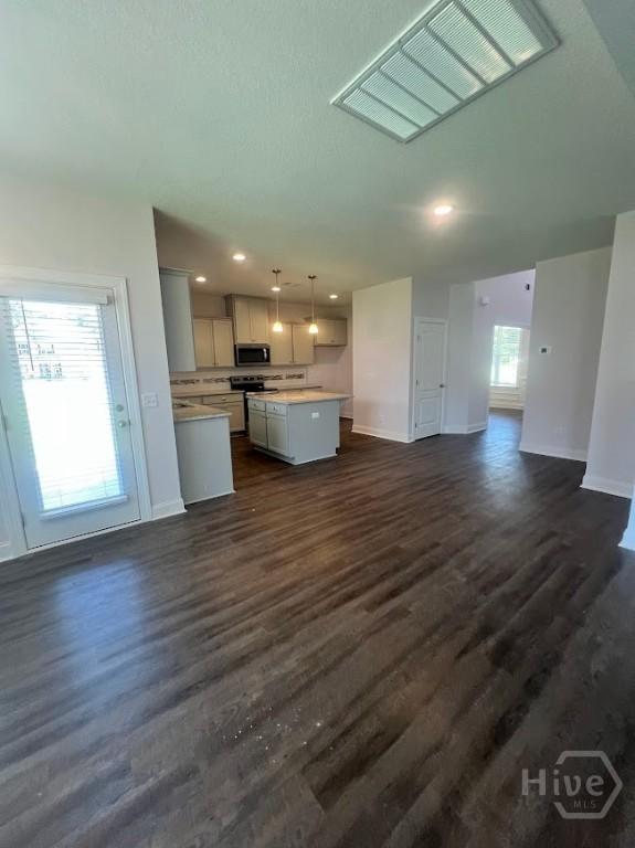 139 Sams Dr, Guyton, GA 31312 - kitchen featuring stainless steel microwave, open floor plan, light countertops, a kitchen island, and baseboards