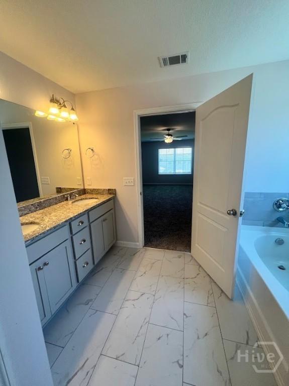 139 Sams Dr, Guyton, GA 31312 - full bathroom featuring double vanity, a garden tub, marble finish floors, and baseboards