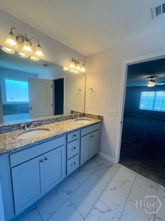 139 Sams Dr, Guyton, GA 31312 - bathroom featuring double vanity, marble look tiles, and baseboards