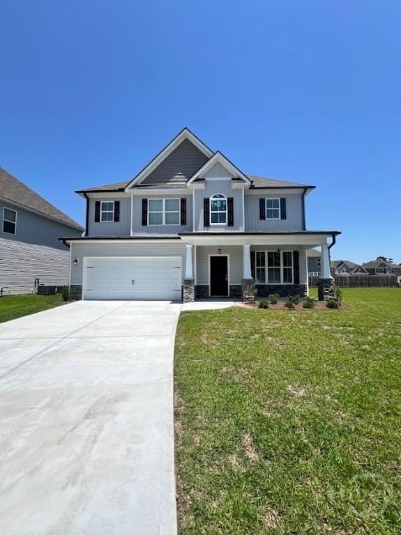 139 Sams Dr, Guyton, GA 31312 - craftsman-style home with a garage, concrete driveway, a front lawn, and covered porch