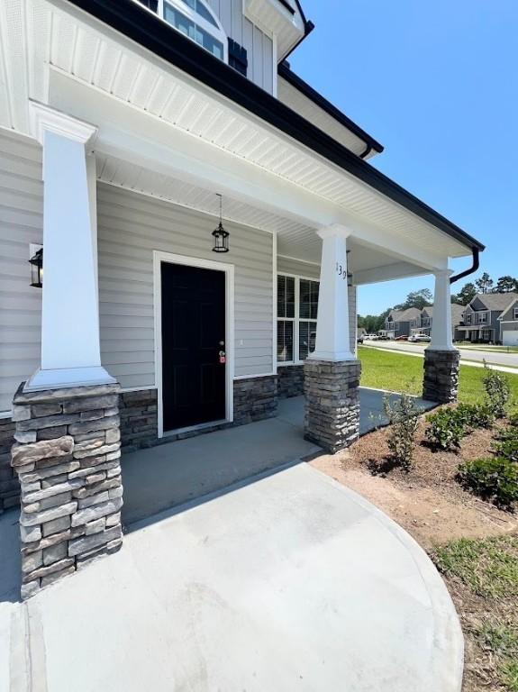 139 Sams Dr, Guyton, GA 31312 - doorway to property featuring a porch and stone siding