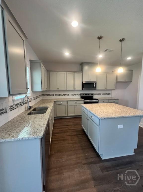 139 Sams Dr, Guyton, GA 31312 - kitchen featuring appliances with stainless steel finishes, a sink, dark wood-type flooring, light stone counters, and recessed lighting