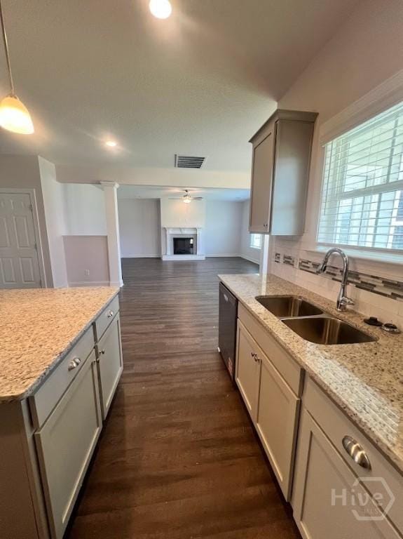 139 Sams Dr, Guyton, GA 31312 - kitchen featuring dishwashing machine, a sink, dark wood finished floors, tasteful backsplash, and light stone countertops
