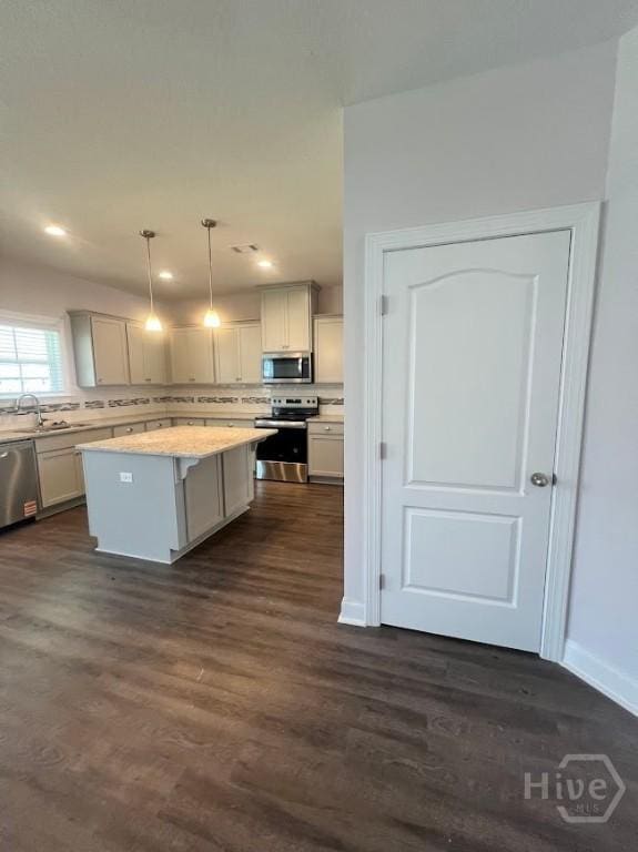 139 Sams Dr, Guyton, GA 31312 - kitchen with appliances with stainless steel finishes, a center island, light countertops, dark wood finished floors, and a sink