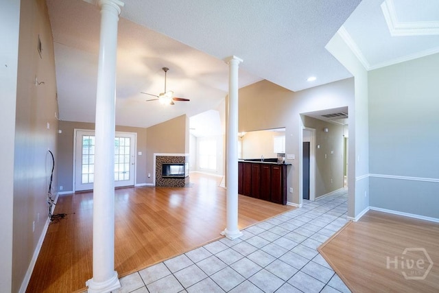 143 Village Lake Dr, Pooler, GA 31322 - unfurnished living room featuring a tile fireplace, ceiling fan, ornate columns, light tile patterned floors, and baseboards