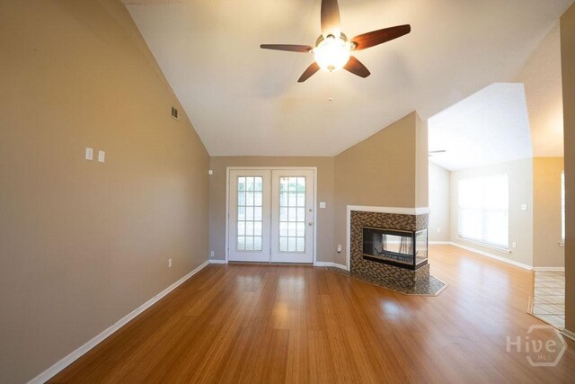 143 Village Lake Dr, Pooler, GA 31322 - unfurnished living room with ceiling fan, a tile fireplace, vaulted ceiling, wood finished floors, and baseboards