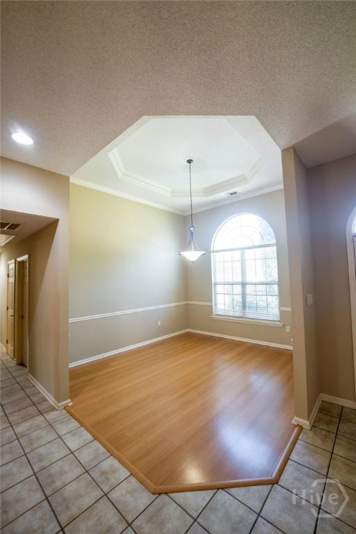 143 Village Lake Dr, Pooler, GA 31322 - spare room featuring a raised ceiling, baseboards, light tile patterned floors, ornamental molding, and a textured ceiling