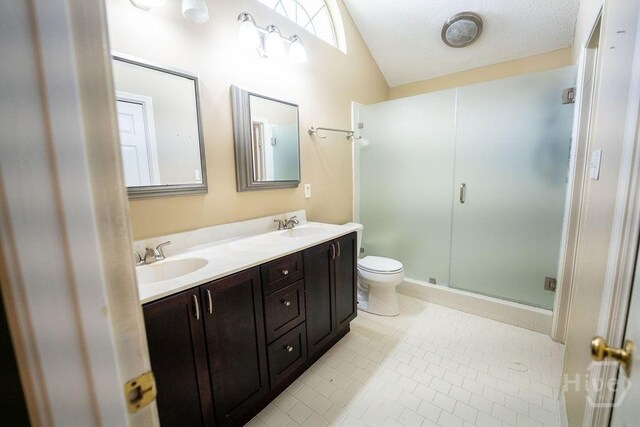 143 Village Lake Dr, Pooler, GA 31322 - bathroom with double vanity, vaulted ceiling, toilet, tile patterned floors, and a stall shower