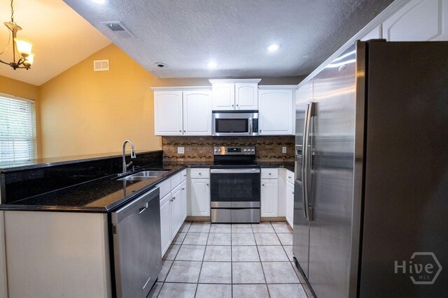 143 Village Lake Dr, Pooler, GA 31322 - kitchen with stainless steel appliances, a sink, decorative backsplash, white cabinetry, and a peninsula