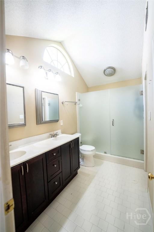 143 Village Lake Dr, Pooler, GA 31322 - bathroom featuring lofted ceiling, double vanity, toilet, a shower stall, and tile patterned floors
