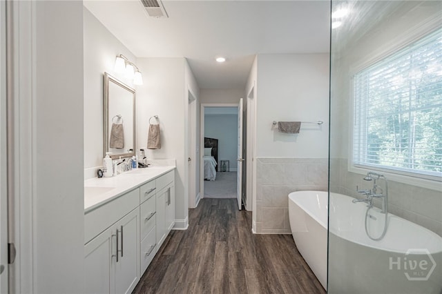 32 Brookhaven Dr, Savannah, GA 31407 - full bath featuring double vanity, a soaking tub, ensuite bathroom, wood finished floors, and tile walls