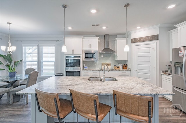 32 Brookhaven Dr, Savannah, GA 31407 - kitchen with wall chimney exhaust hood, stainless steel appliances, crown molding, a chandelier, and a kitchen island with sink