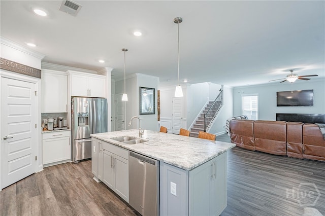 32 Brookhaven Dr, Savannah, GA 31407 - kitchen with stainless steel appliances, open floor plan, wood finished floors, white cabinets, and a ceiling fan