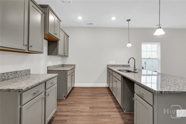 142 Guana Ln, Bloomingdale, GA 31302 - kitchen with gray cabinetry, a peninsula, dark wood finished floors, light stone counters, and a sink