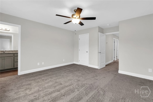 142 Guana Ln, Bloomingdale, GA 31302 - unfurnished bedroom with dark colored carpet, baseboards, ensuite bathroom, ceiling fan, and a sink