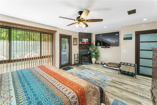 124 Denham Ln, Midway, GA 31320 - bedroom featuring multiple windows, wood finished floors, access to outside, a large fireplace, and recessed lighting