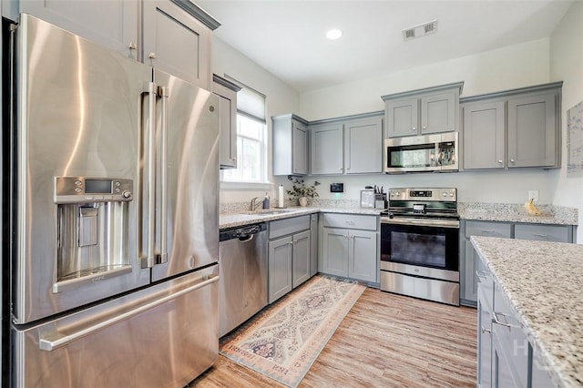 109 Amelia Ct, Guyton, GA 31312 - kitchen featuring stainless steel appliances, gray cabinets, light wood-style flooring, light stone countertops, and recessed lighting