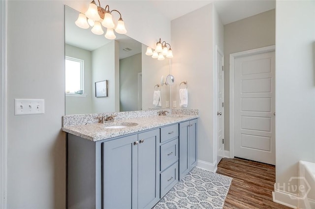 109 Amelia Ct, Guyton, GA 31312 - bathroom with a chandelier, double vanity, wood finished floors, and baseboards