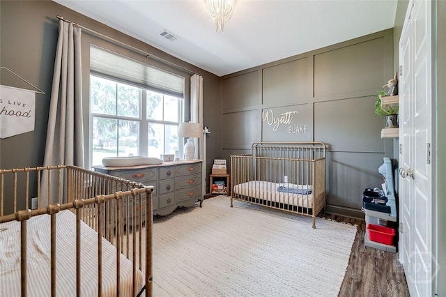 109 Amelia Ct, Guyton, GA 31312 - bedroom featuring a decorative wall, wood finished floors, and a nursery area