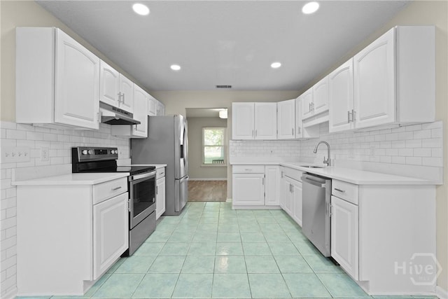 121 Warner Dr, Guyton, GA 31312 - kitchen with stainless steel appliances, under cabinet range hood, a sink, white cabinets, and recessed lighting