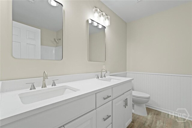 121 Warner Dr, Guyton, GA 31312 - bathroom with a wainscoted wall, double vanity, toilet, wood finished floors, and a shower
