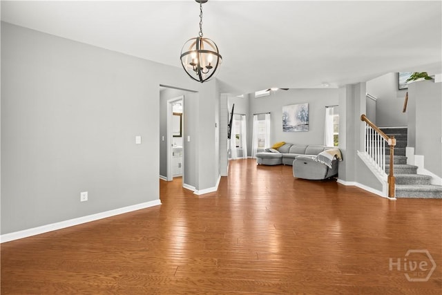 46 Central Park Way, Savannah, GA 31407 - unfurnished living room featuring stairs, a chandelier, wood finished floors, baseboards, and vaulted ceiling