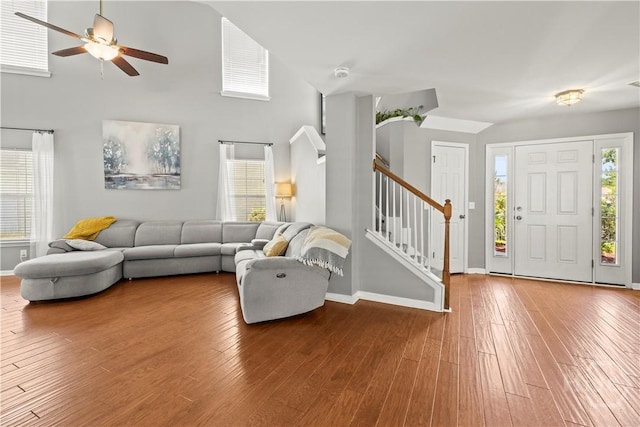 46 Central Park Way, Savannah, GA 31407 - living area with stairway, ceiling fan, wood-type flooring, baseboards, and a high ceiling
