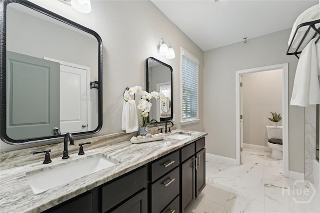 2142 New York Ave, Savannah, GA 31404 - bathroom with marble look tile flooring, double vanity, toilet, and baseboards