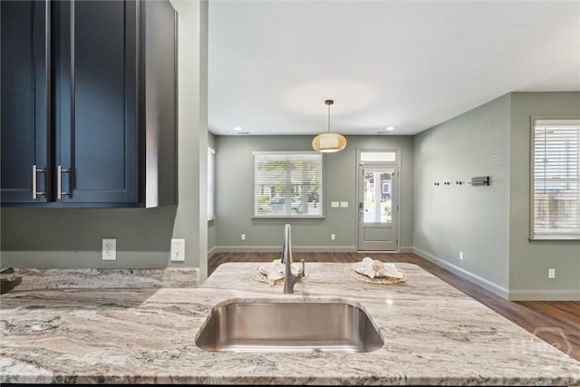 2142 New York Ave, Savannah, GA 31404 - kitchen featuring a sink, wood finished floors, light stone countertops, hanging light fixtures, and baseboards