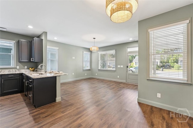 2142 New York Ave, Savannah, GA 31404 - kitchen with a sink, a chandelier, baseboards, light stone counters, and decorative light fixtures