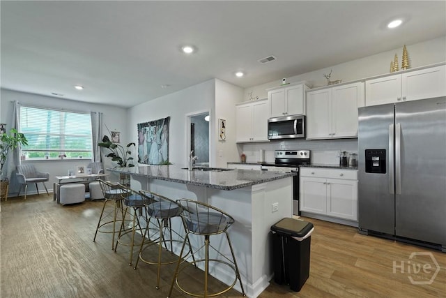 116 Fremont Ln, Pooler, GA 31322 - kitchen featuring stainless steel appliances, a sink, light wood-style flooring, a breakfast bar area, and a center island with sink