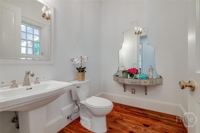 36 Belted Kingfisher Ln, Richmond Hill, GA 31324 - bathroom featuring toilet, wood finished floors, a sink, a chandelier, and baseboards
