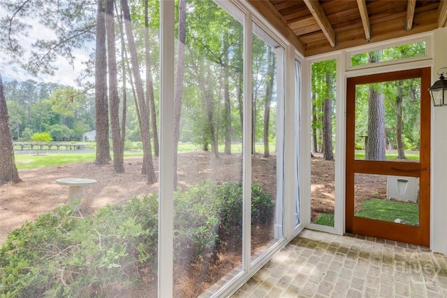 36 Belted Kingfisher Ln, Richmond Hill, GA 31324 - unfurnished sunroom featuring wooden ceiling with exposed beams and brick flooring