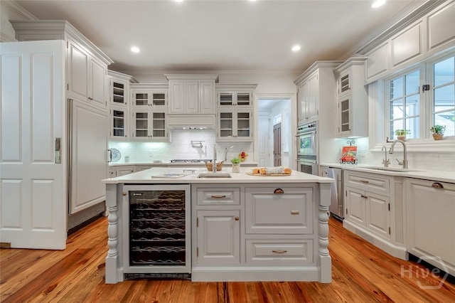 36 Belted Kingfisher Ln, Richmond Hill, GA 31324 - kitchen with wine cooler, a sink, light countertops, white cabinetry, and recessed lighting